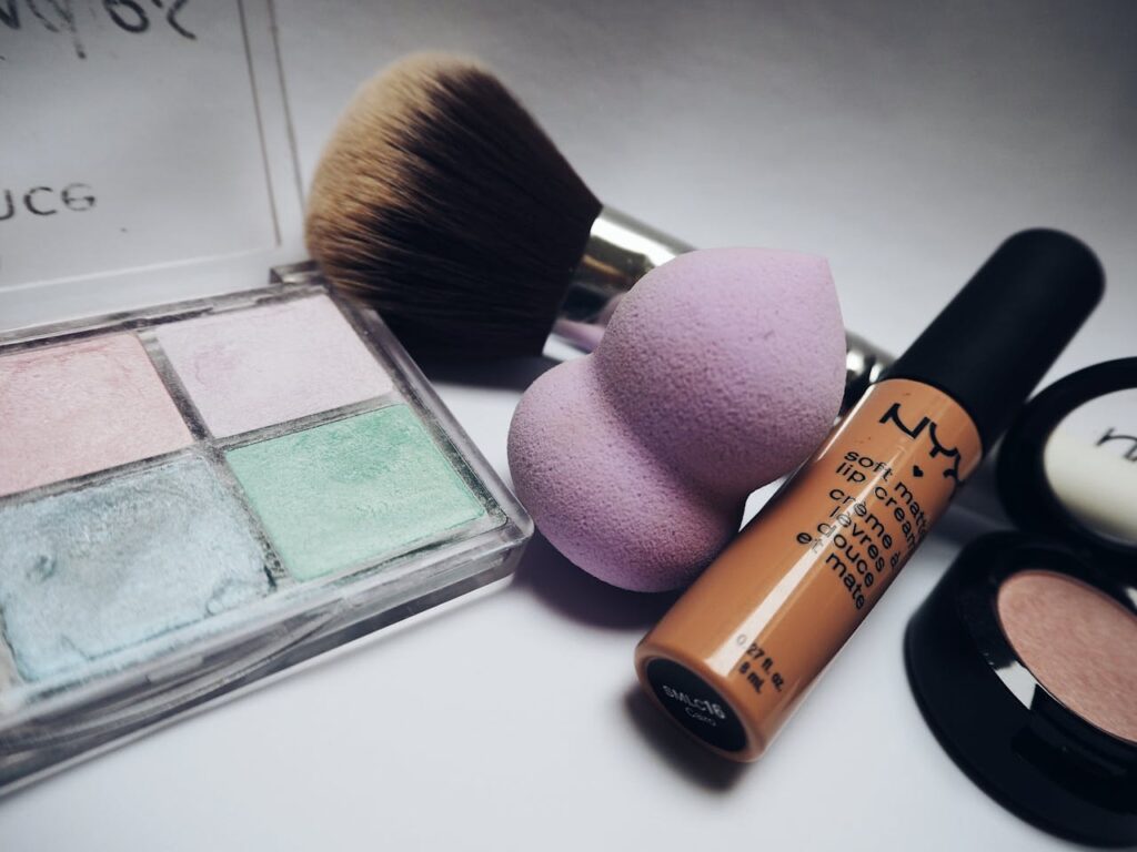 A flat lay showcasing various makeup essentials including brushes, sponges, and cosmetics.